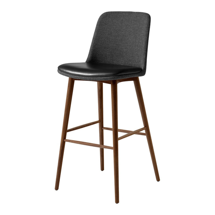 Black upholstered bar stool with curved backrest and wooden legs. Modern design with a minimalist aesthetic.