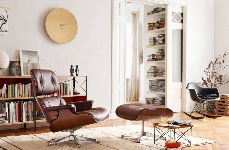 Modern brown leather lounge chair and ottoman, accented by neutral tones and geometric patterns in a minimalist setting.