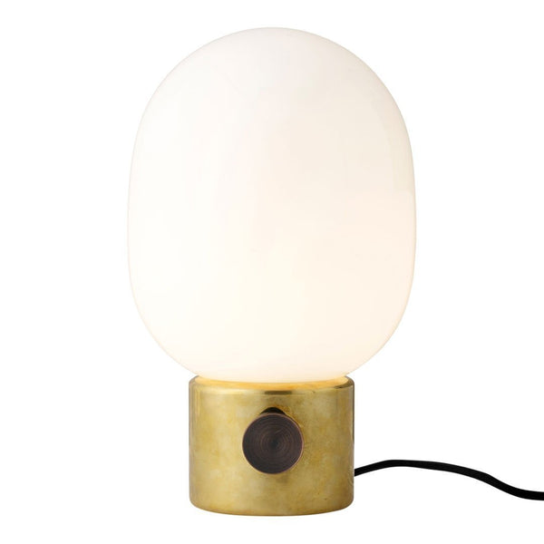 White glass lamp with an oval shape, brass base, and black switch for a modern, minimalist design.