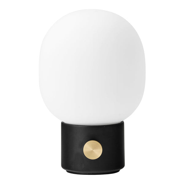 White glass lamp with a round shape, black base, and a brass button accent for a modern touch.