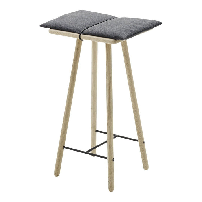 Gray upholstered seat on a minimalist wooden stool with natural finish and black metal accents.