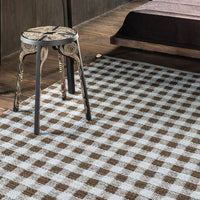 Brown and white checked pattern area rug, adding a cozy touch to modern decor. Perfect for any room setting.