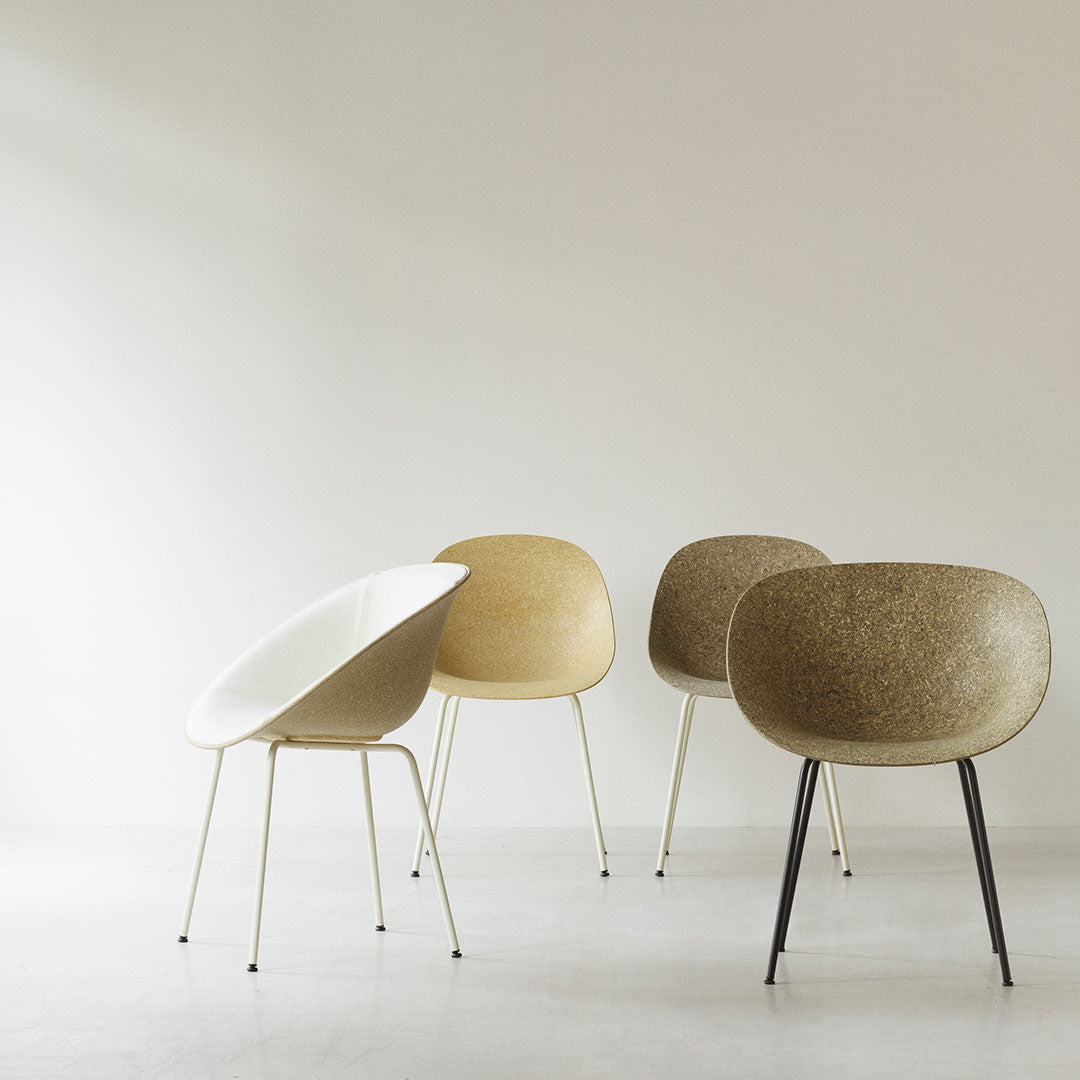 "Four stylish chairs in white, beige, and brown with smooth, rounded shapes and sleek metal legs."