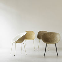 "Four stylish chairs in white, beige, and brown with smooth, rounded shapes and sleek metal legs."