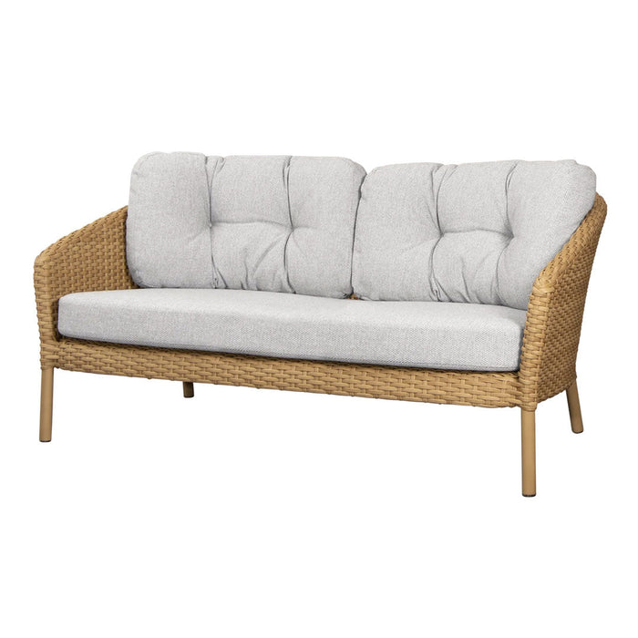 Light gray tufted cushions with a natural wicker frame, showcasing a modern, cozy design perfect for outdoor spaces.
