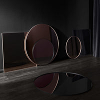 Elegant circular mirrors featuring deep burgundy and sleek black finishes, showcasing modern minimalist design.