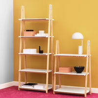 "Modern wooden shelves with white surfaces, accentuated by a vibrant yellow wall and a soft pink carpet."