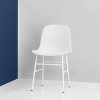 White modern chair against a gray and navy backdrop, featuring a sleek, minimal design and smooth surfaces.