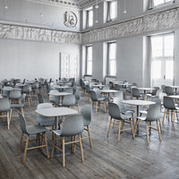 Minimalist gray chairs and tables on a light wood floor in a spacious, well-lit room with a classic design.