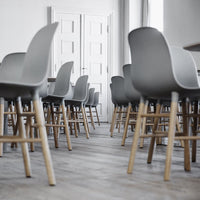 Gray chairs with wooden legs arranged in a modern setting, featuring simple lines and a minimalist aesthetic.