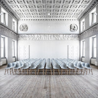 Light blue chairs with natural wood legs arranged in a minimalistic, elegant indoor setting with a white ceiling.