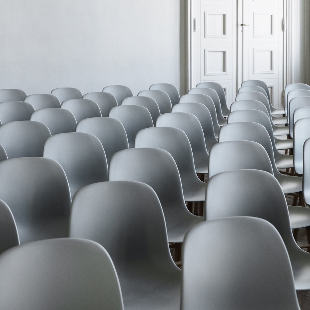 Gray modern chairs arranged in rows, featuring smooth, minimalistic design and subtle shadows throughout.