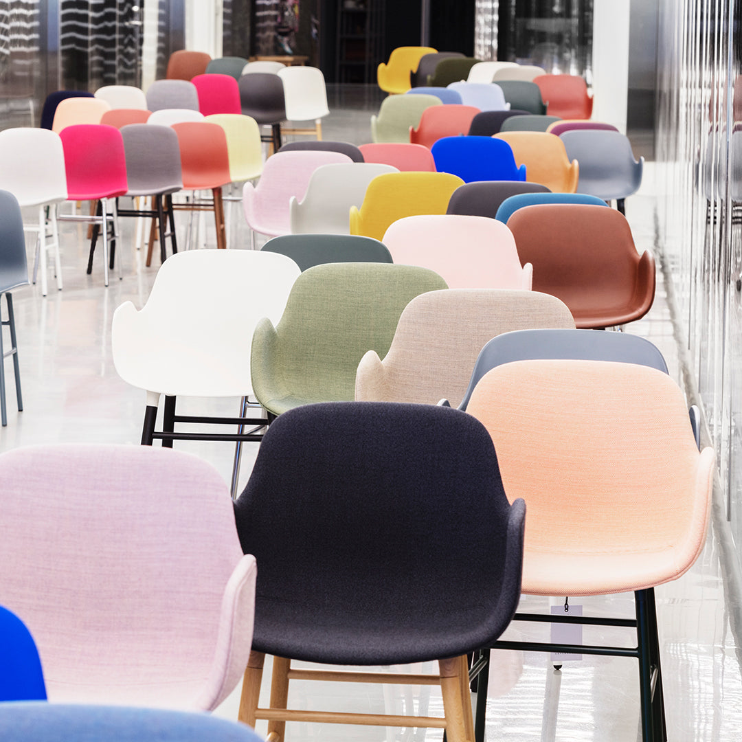 Colorful array of chairs featuring soft pastels and vibrant hues, with varied patterns and finishes.