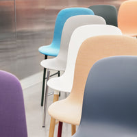 Colorful modern chairs in shades of blue, white, peach, grey, and purple, featuring sleek, minimalist designs.