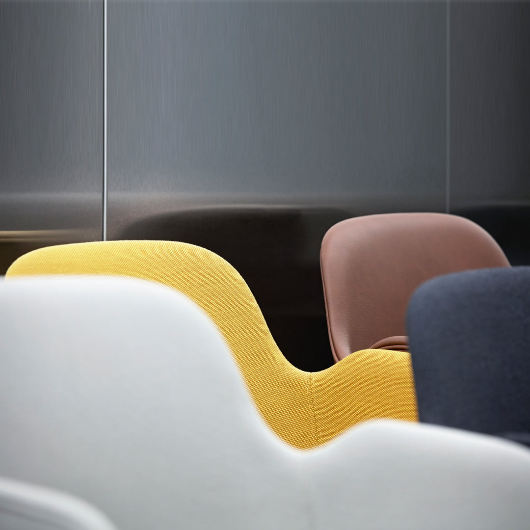 Colorful modern chairs featuring yellow, pink, and gray curves against a sleek gray background. Stylish design accents.