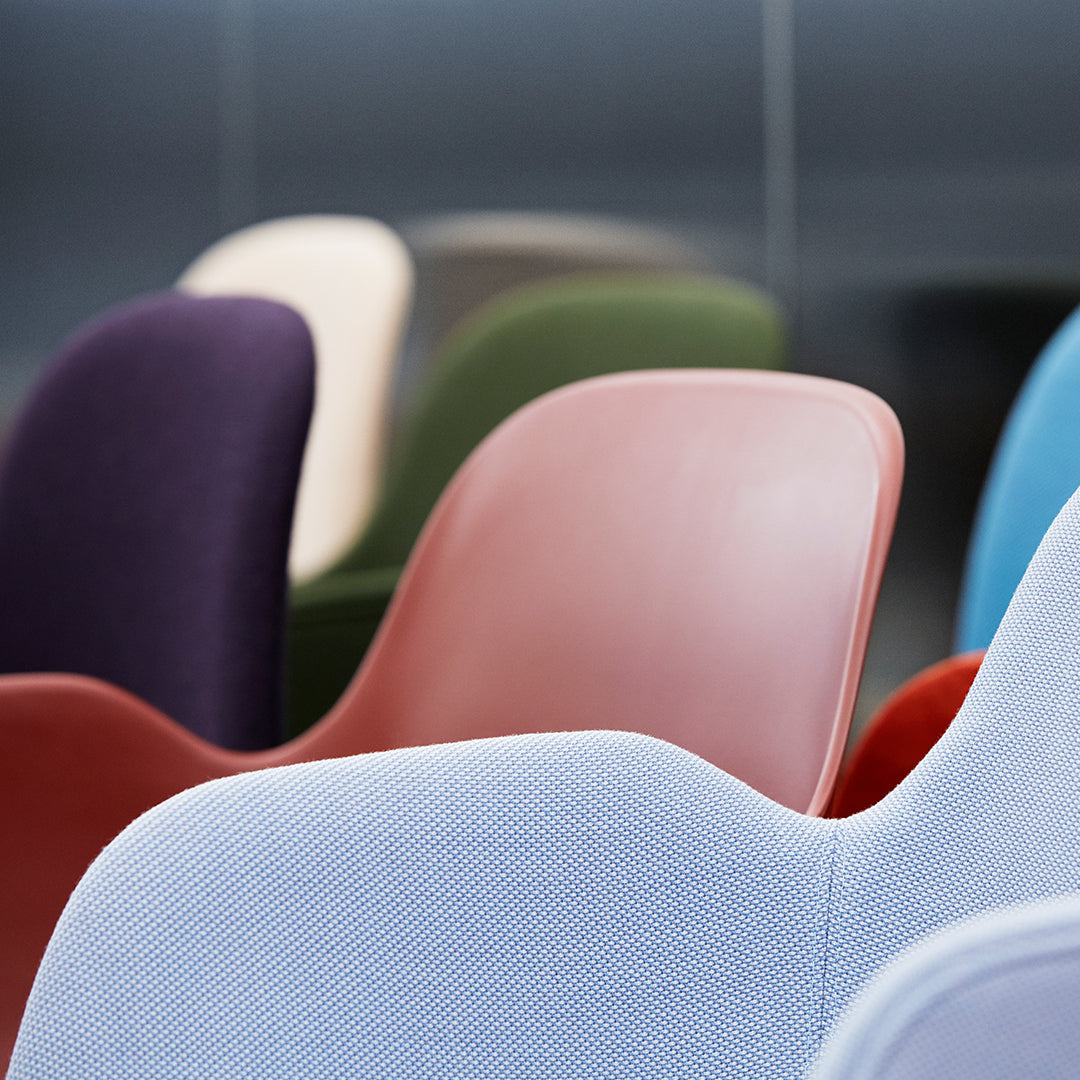 Colorful modern chairs in varying shades of purple, green, red, and blue with smooth, sleek finishes.