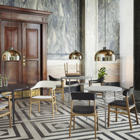 Modern dining space featuring black, white, and wooden tones with geometric black-and-white floor pattern.