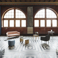 Elegant room with warm wood tones, geometric black and white patterned flooring, and pastel furniture accents.