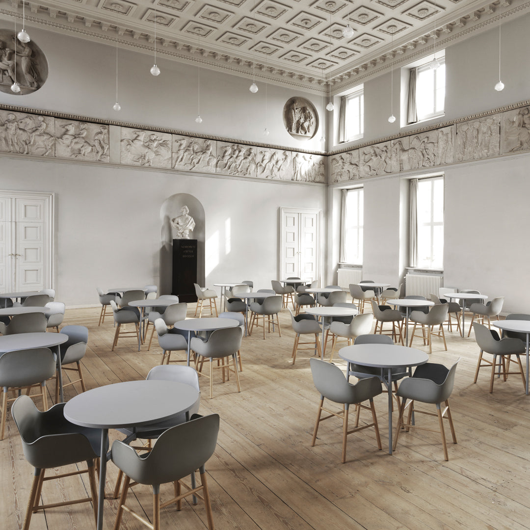 Gray chairs with light blue tabletops in an elegant, spacious room featuring intricate ceiling patterns.