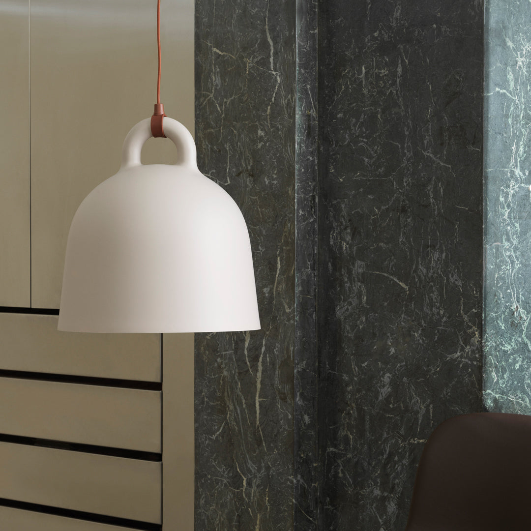 White dome pendant lamp with a minimalistic design, featuring a smooth surface and contrasting red hanging cord.