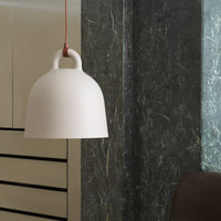 White dome pendant lamp with a minimalistic design, featuring a smooth surface and contrasting red hanging cord.