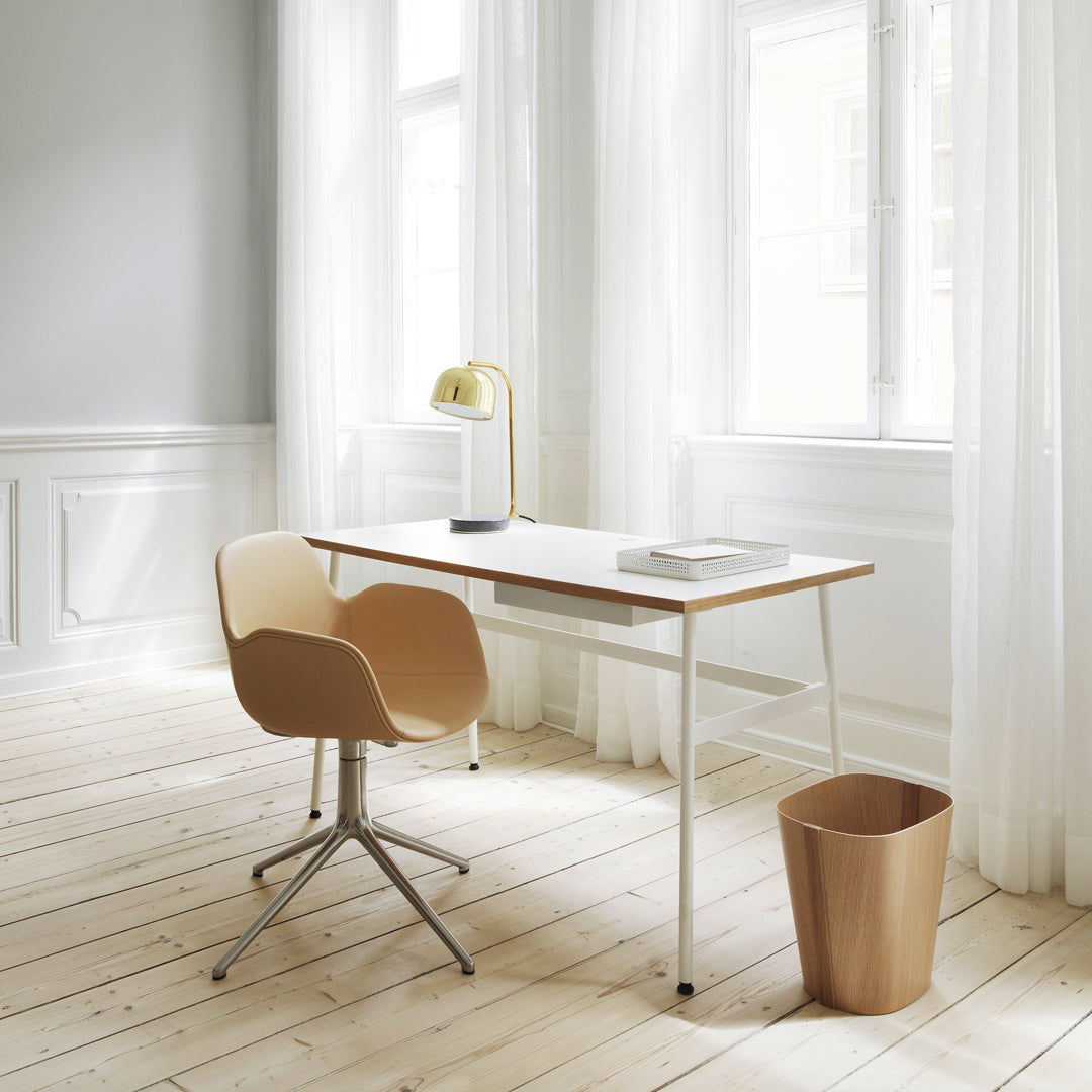 Modern desk with a minimalist design, featuring light wood, soft beige chair, and subtle gray walls.