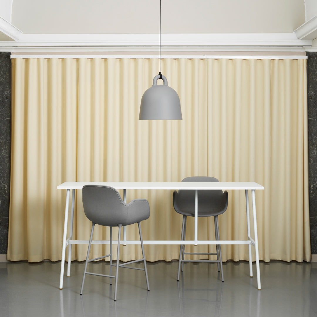 Elegant beige pleated curtains with smooth texture, enhancing a modern interior with grey furniture accents.