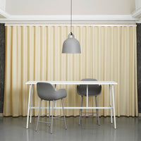 Elegant beige pleated curtains with smooth texture, enhancing a modern interior with grey furniture accents.
