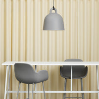 Gray pendant lamp above white table with gray chairs and textured beige curtain backdrop.