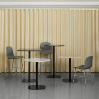 Modern furniture set featuring gray chairs and tables with black bases, against a warm beige curtain backdrop.