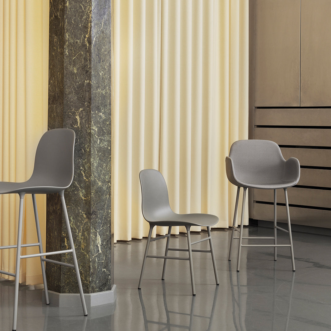 Stylish gray chairs on polished floor with soft yellow drapes, creating a modern, sophisticated ambiance.