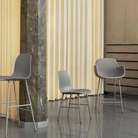 Stylish gray chairs on polished floor with soft yellow drapes, creating a modern, sophisticated ambiance.