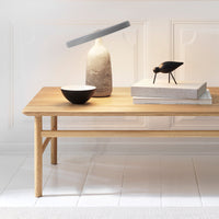 Natural wood coffee table with light beige and gray accents, featuring minimalist decor in neutral tones.