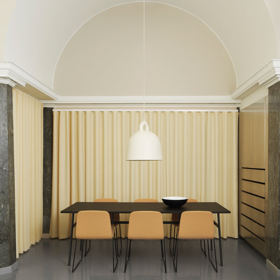 Minimalist dining room with beige curtains, soft cream walls, and sleek black furniture. Stylish modern design elements.