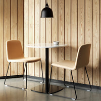 Scandinavian-style dining set featuring tan chairs, a white marble table, and black accents against a wooden backdrop.