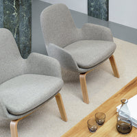 Light gray upholstered chairs with natural wood legs, set on a beige rug in a modern living space.