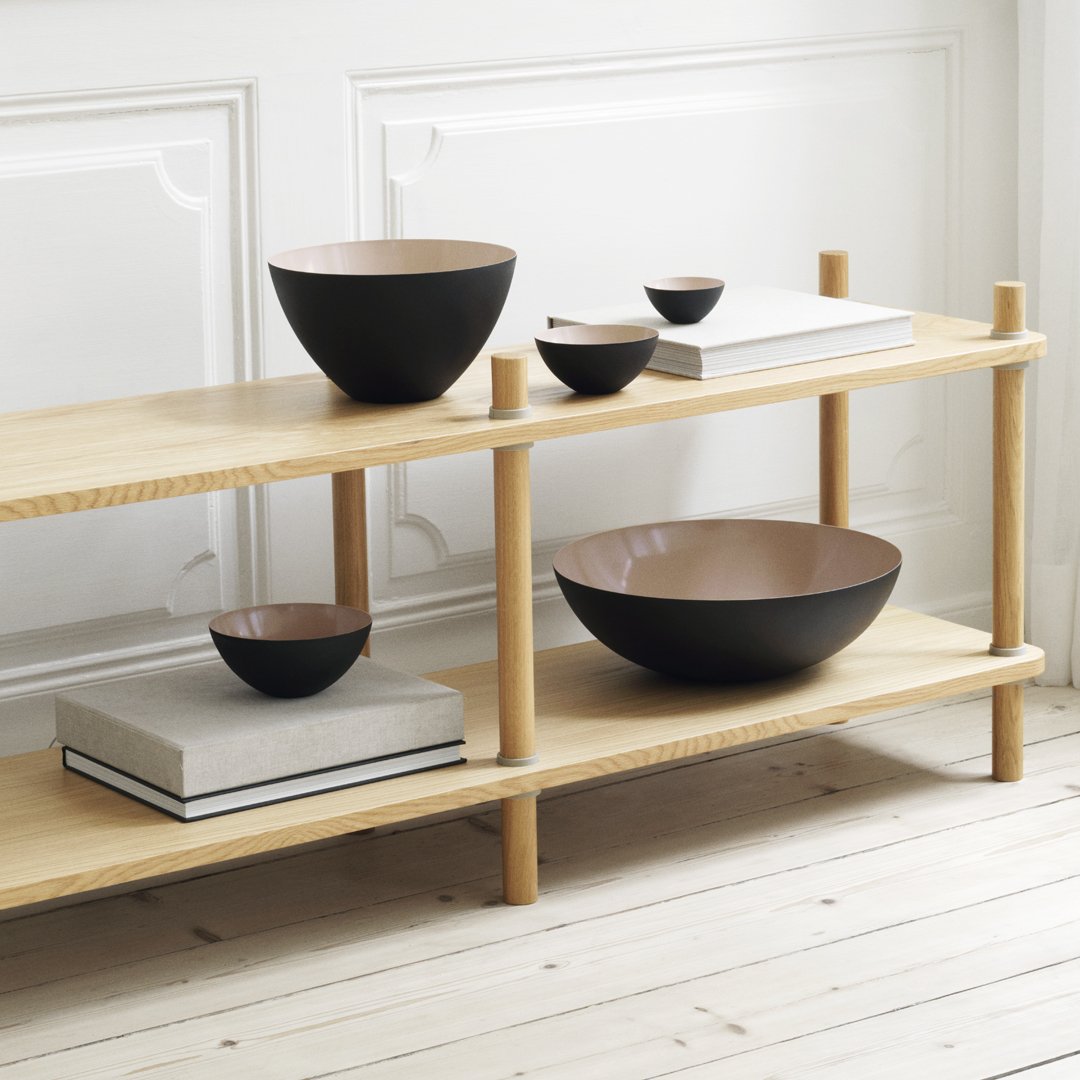 "Set of sleek black and brown bowls on a wooden shelf, showcasing modern design and natural wood tones."