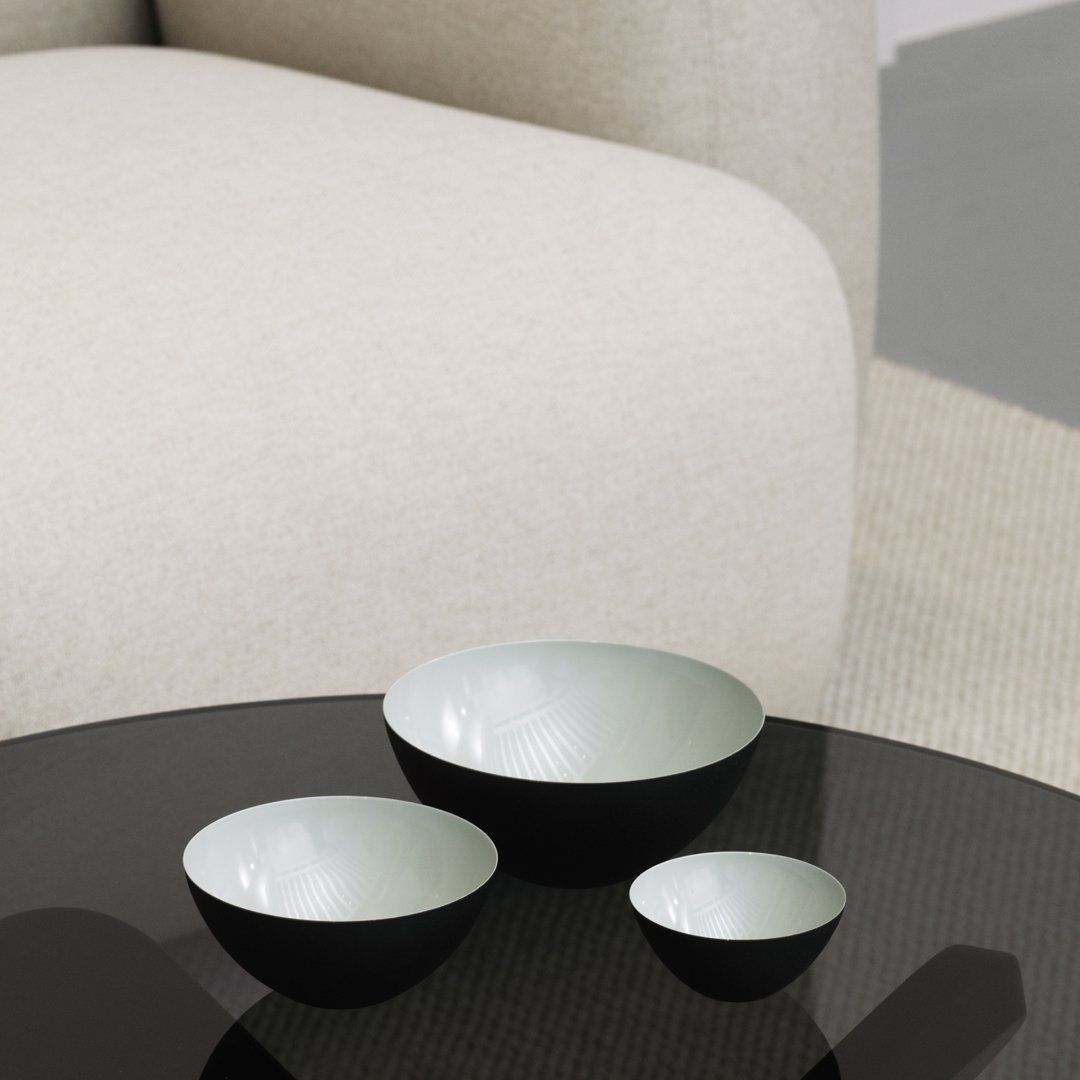 Set of three nested bowls featuring a glossy black exterior and a soft pastel green interior with subtle pattern detailing.