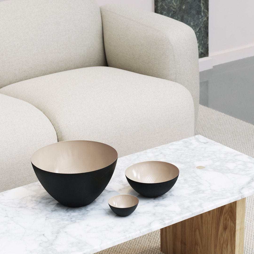 Black and gold nesting bowls on a marble table, featuring a modern design and glossy finishes.