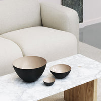 Black and gold nesting bowls on a marble table, featuring a modern design and glossy finishes.