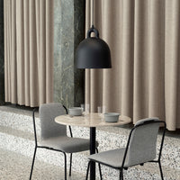 Gray chairs and table paired with a black pendant lamp against beige curtains for a modern, minimalistic look.