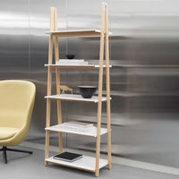Light wood shelving unit with white shelves, featuring a sleek, modern design against a metallic background.