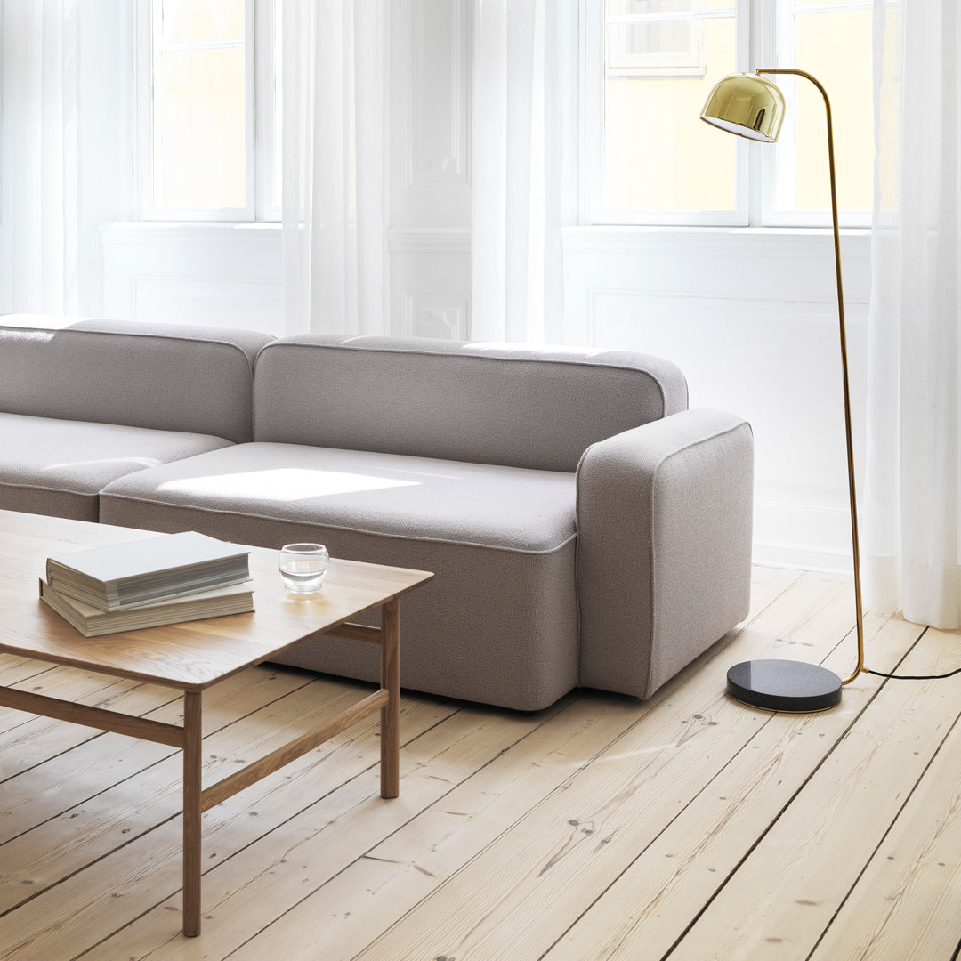 Light gray sofa with clean lines, complemented by a minimalist wooden table and a stylish yellow lamp.
