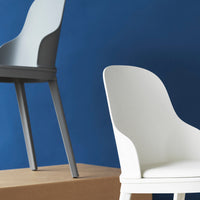 Gray and white modern chairs against a deep blue backdrop, showcasing sleek curves and minimalist design.