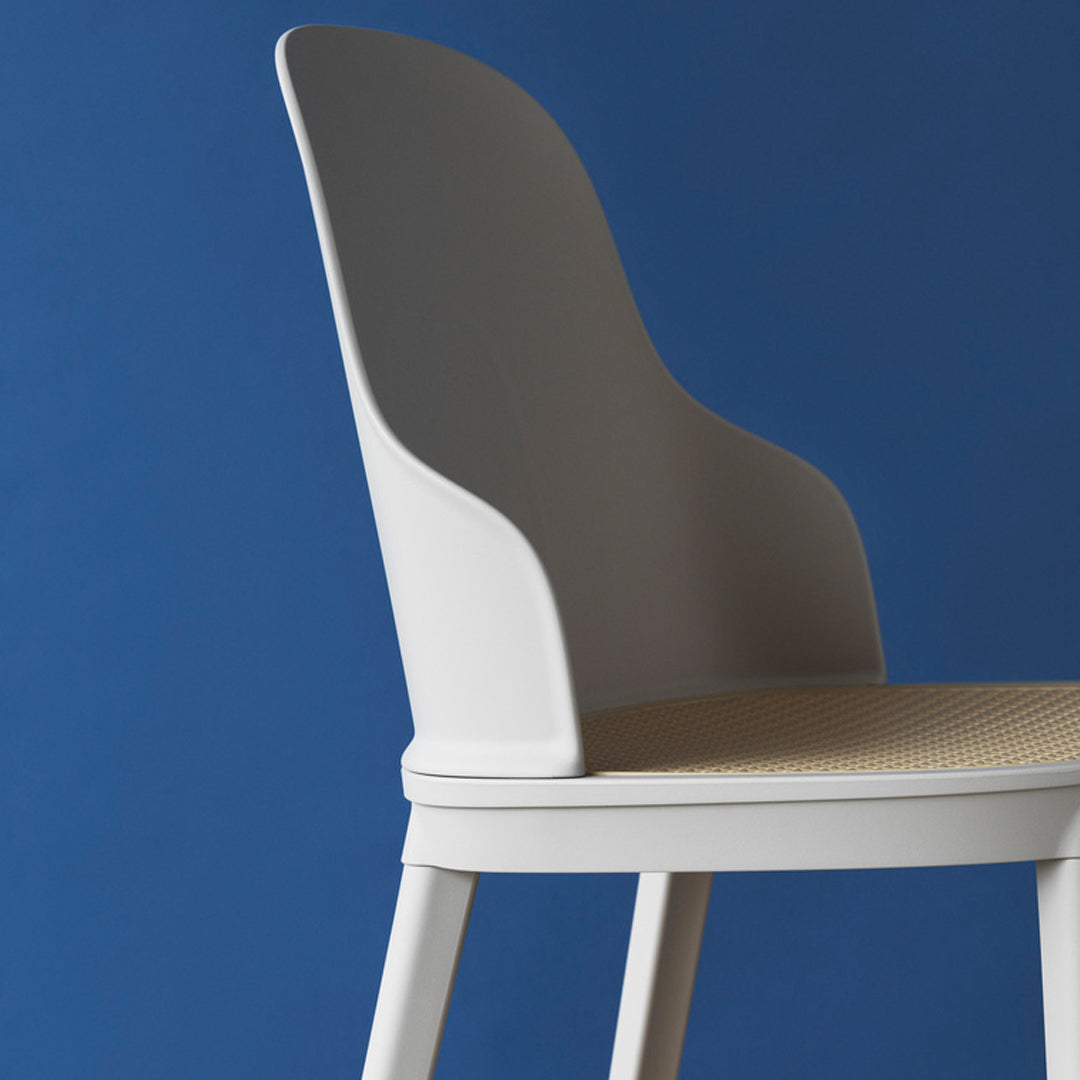 Sleek white chair with a textured beige seat against a vibrant blue background, showcasing clean lines and modern design.