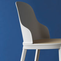Sleek white chair with a textured beige seat against a vibrant blue background, showcasing clean lines and modern design.
