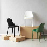 "Stylish chairs in black, white, and green on cardboard boxes against a neutral background."
