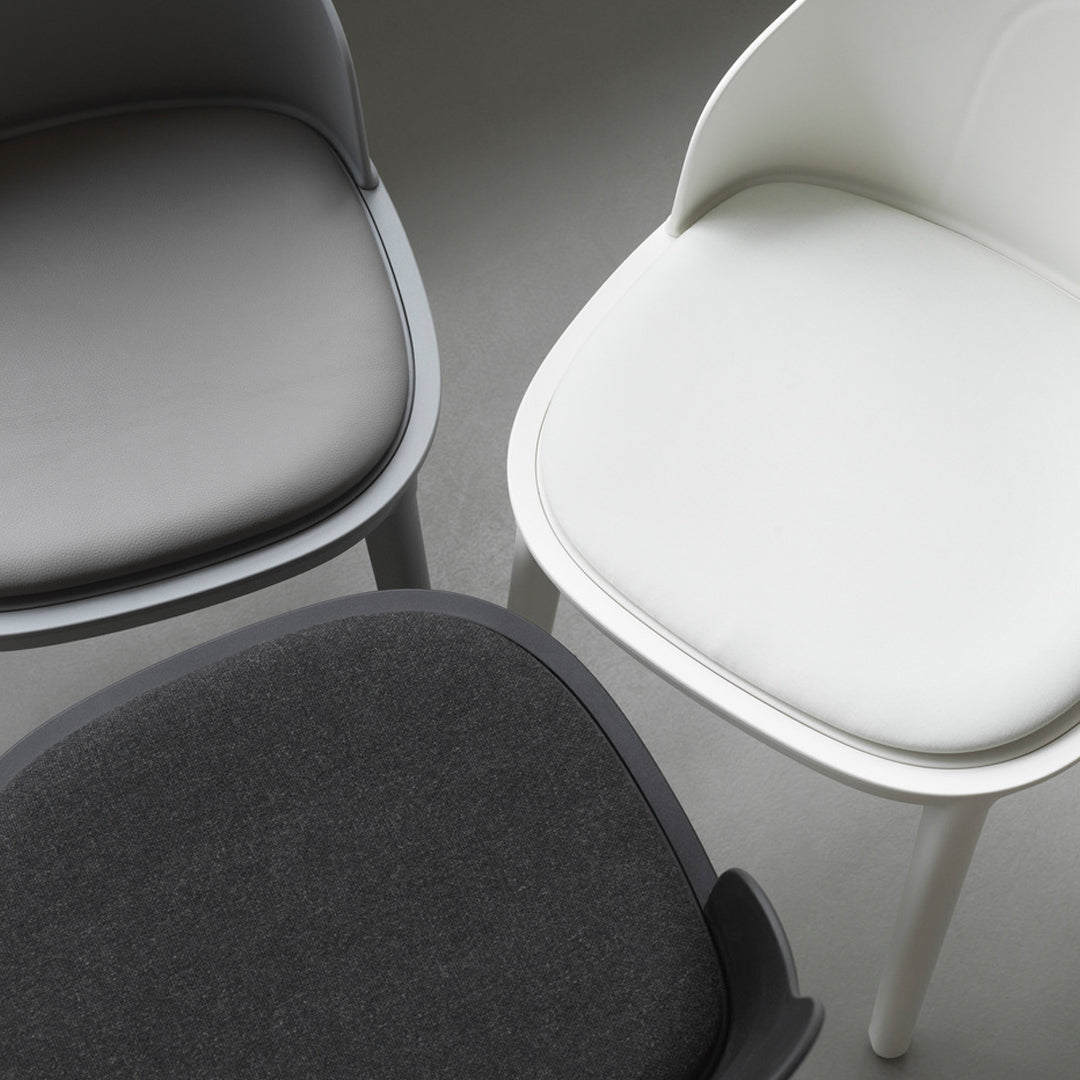 Three modern chairs featuring sleek gray, white, and black upholstery, highlighting minimalist design and subtle textures.