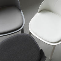 Three modern chairs featuring sleek gray, white, and black upholstery, highlighting minimalist design and subtle textures.