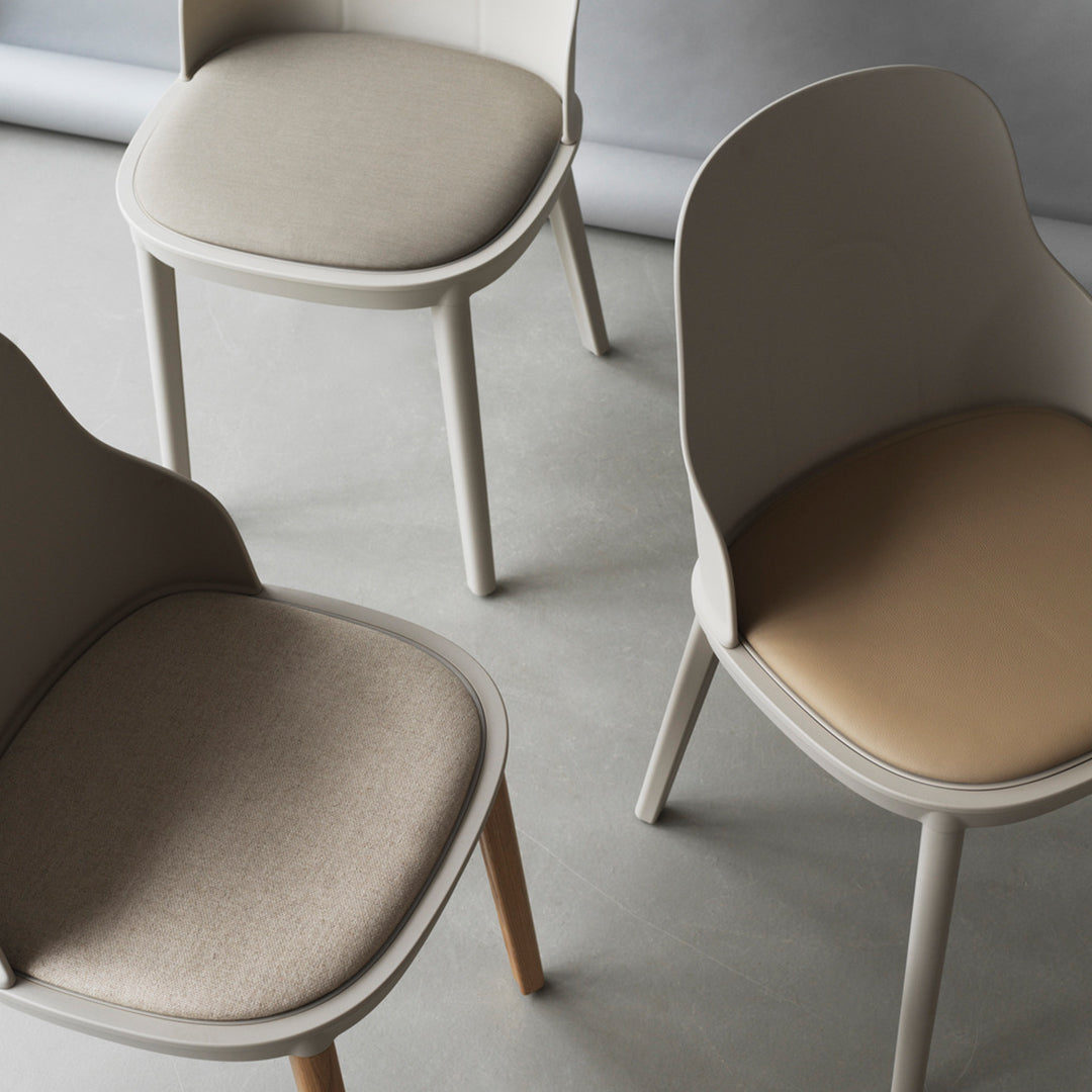 Set of three stylish chairs featuring soft beige and taupe upholstery with a sleek, modern design.